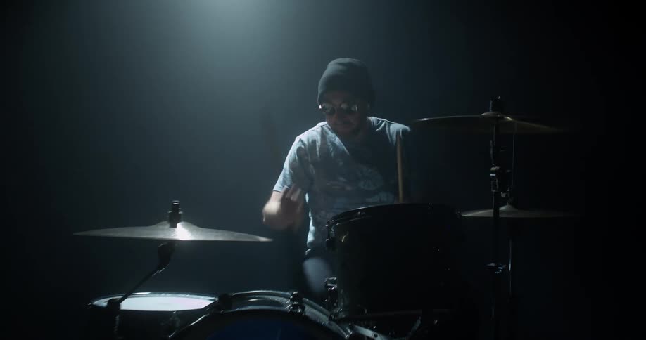 A view of a man playing drums on a stage