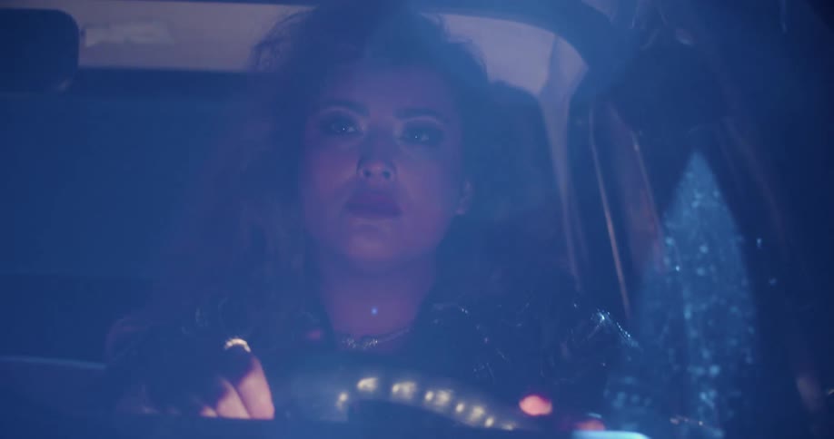 A woman driving a vehicle and turning the steering wheel