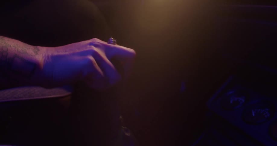 Hand with a ring on a finger shifts gears in an automobile