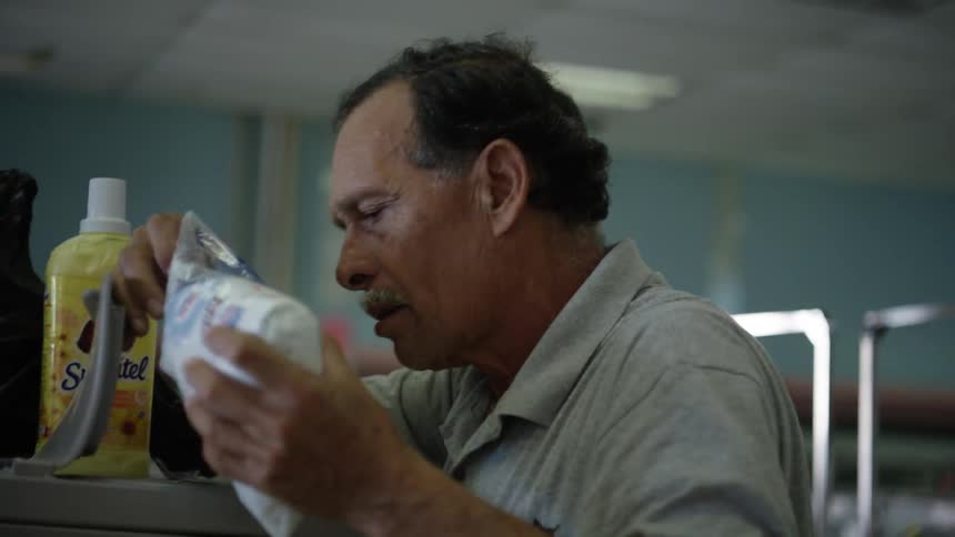 A man pours soap into a washer