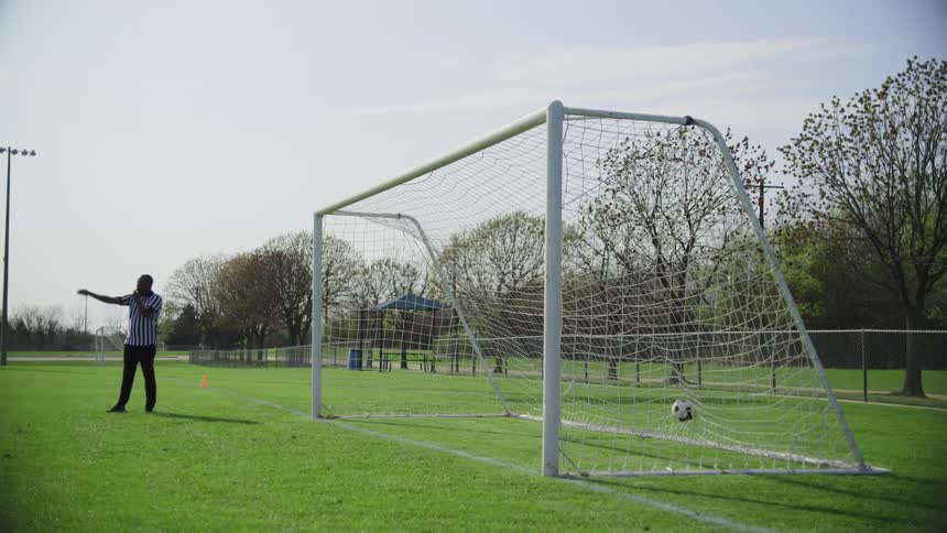 A man is playing soccer on a field in spring