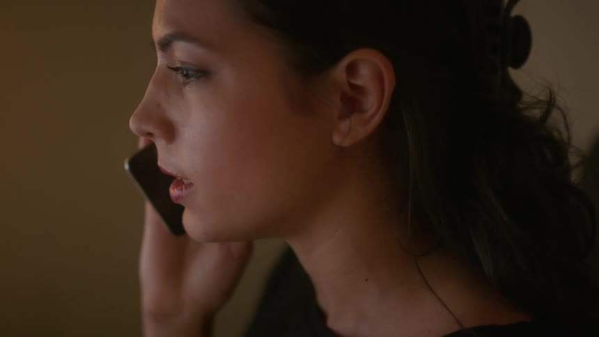 A woman is talking on the phone indoors