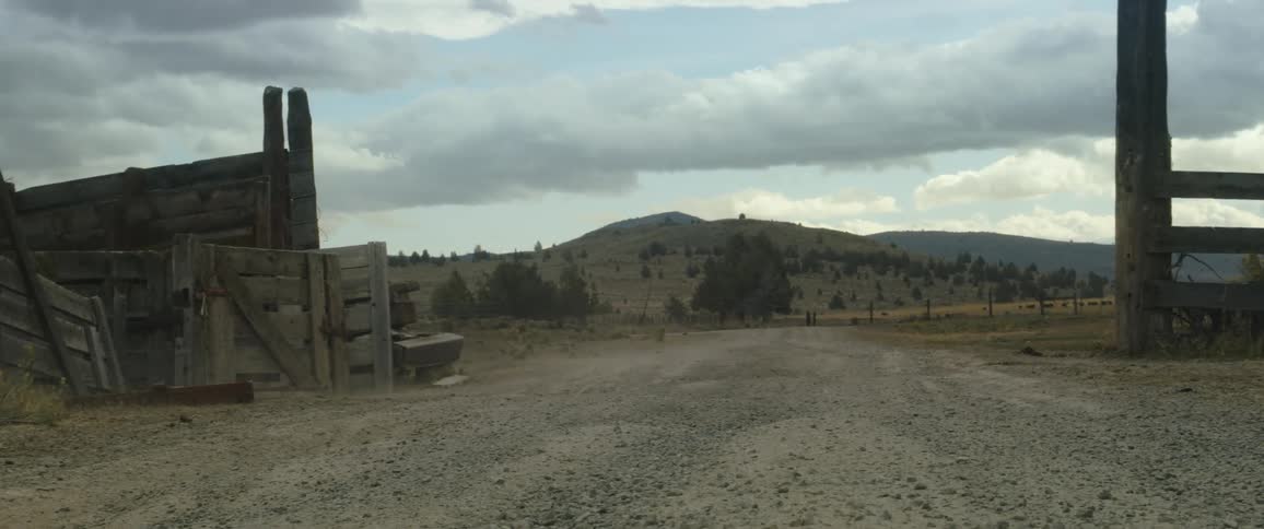 A view of some farmland with wind blowing dust