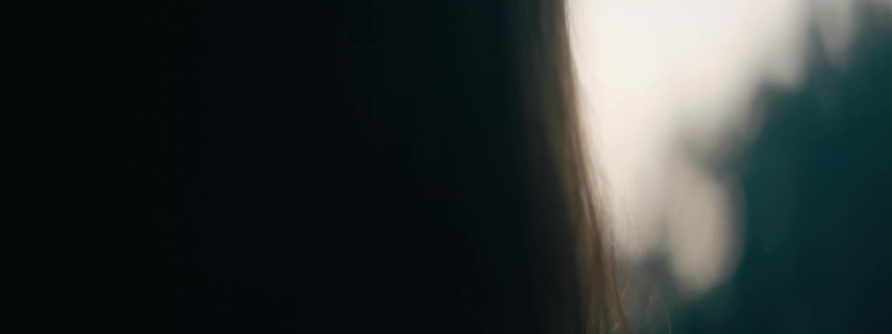 Woman stands facing bright shining golden light