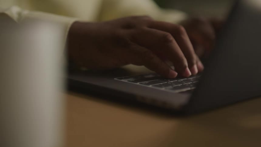 A person is typing on the keyboard on his laptop