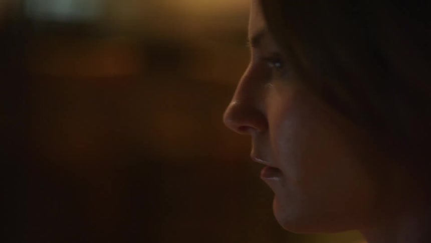 A woman in a room with a wall in the background