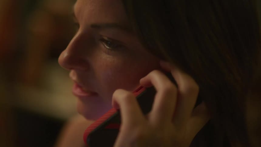 A woman smiles before picking up her phone and answering a call