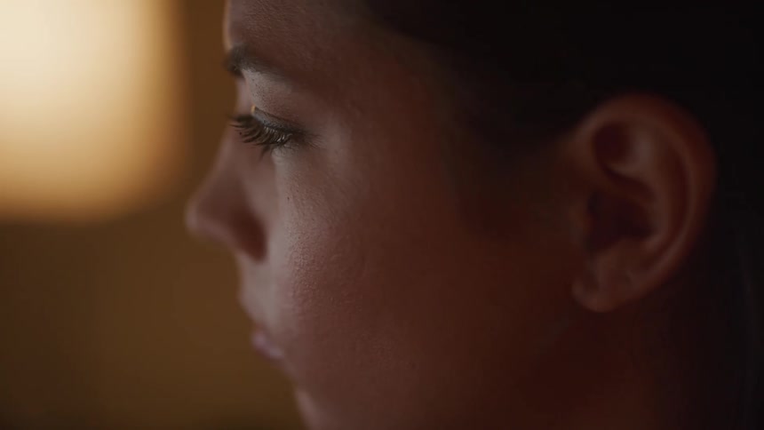 A woman is looking at something and blinking