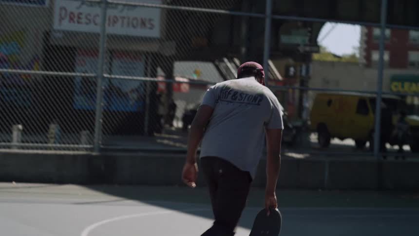 A man is riding a skateboard in a court