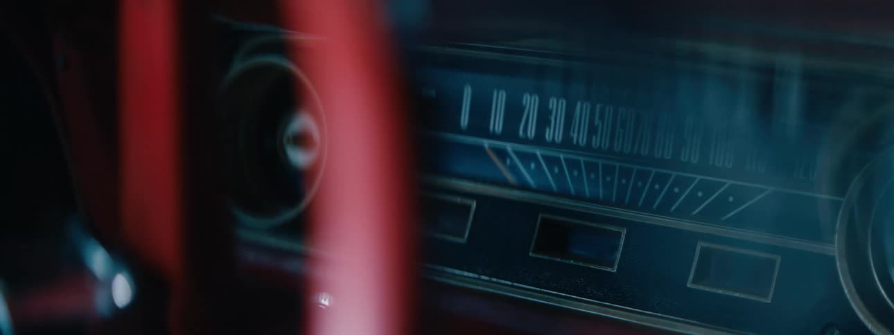 Red steering wheel turns as light brightens speedometer on dash