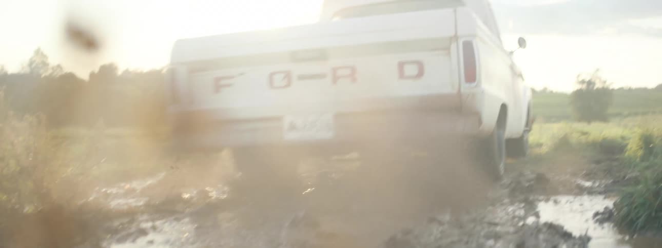 A pickup trucks tire spins in the mud before the truck gets unstuck and drives away