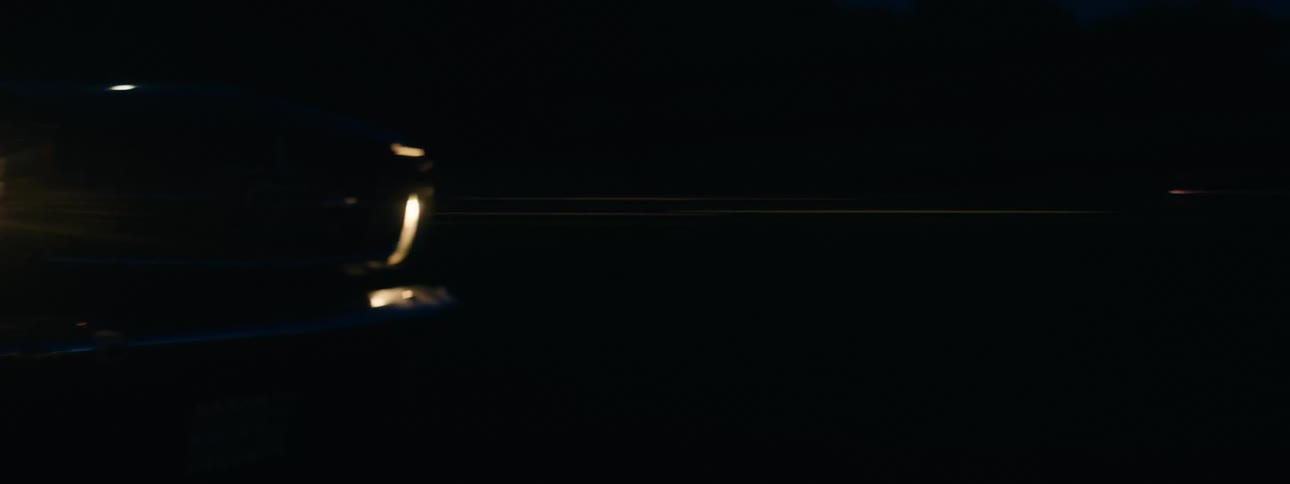 Pickup truck with headlights on driving on the countryside at night