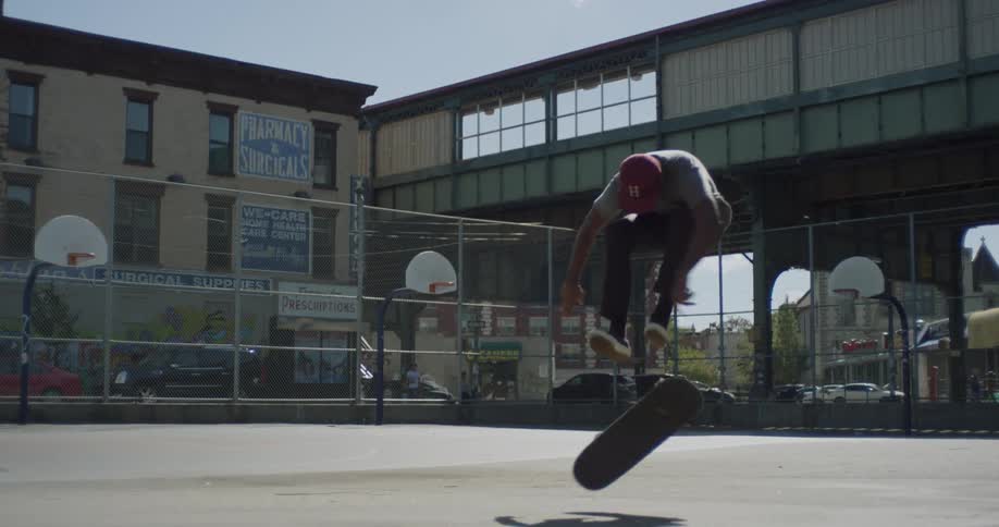 A man does a jump on a skateboard in a park
