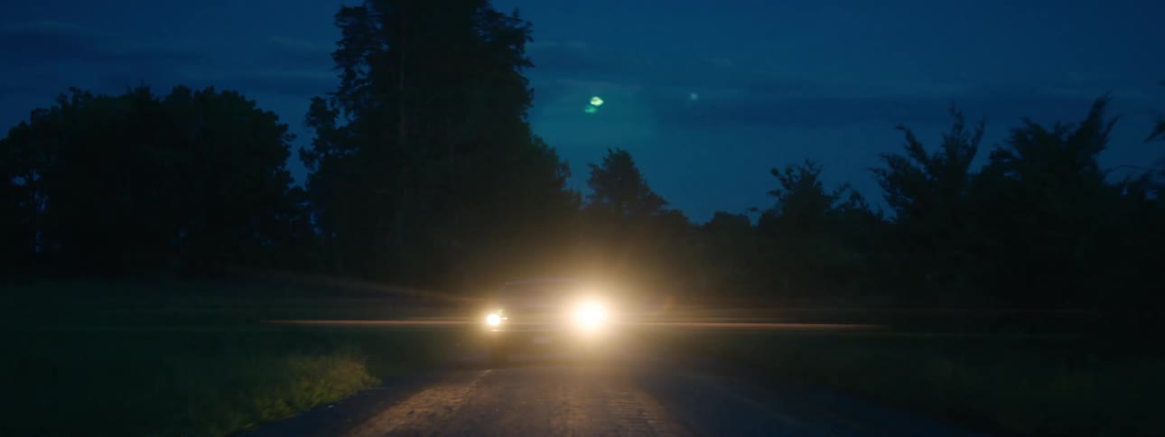 A car driving down a road at night