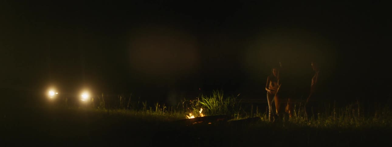 A view of people outside near a campfire