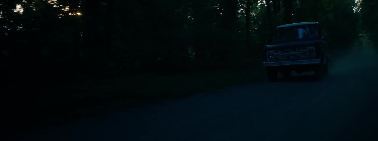 Pickup truck travels on a dirt road in the forest