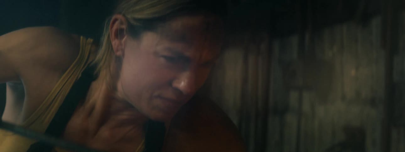 A woman is putting out a fire outdoors at night