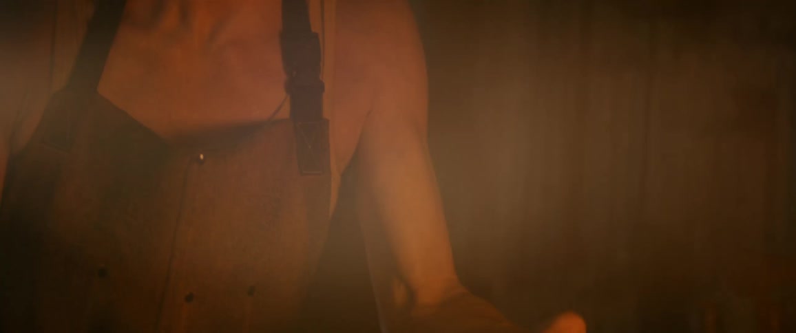 Woman holds metal tongs into a burning fire