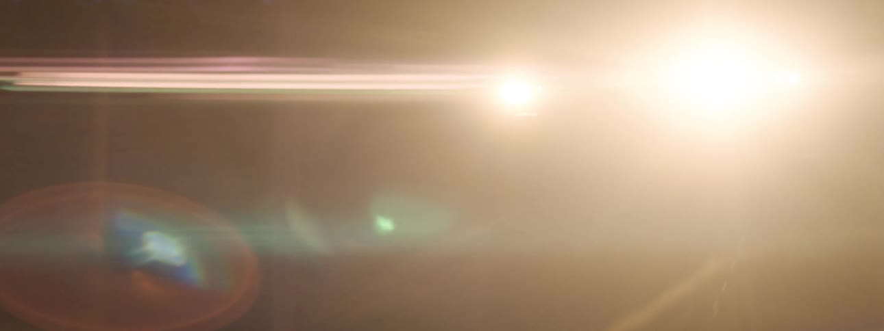A car is driving downa road during the night time