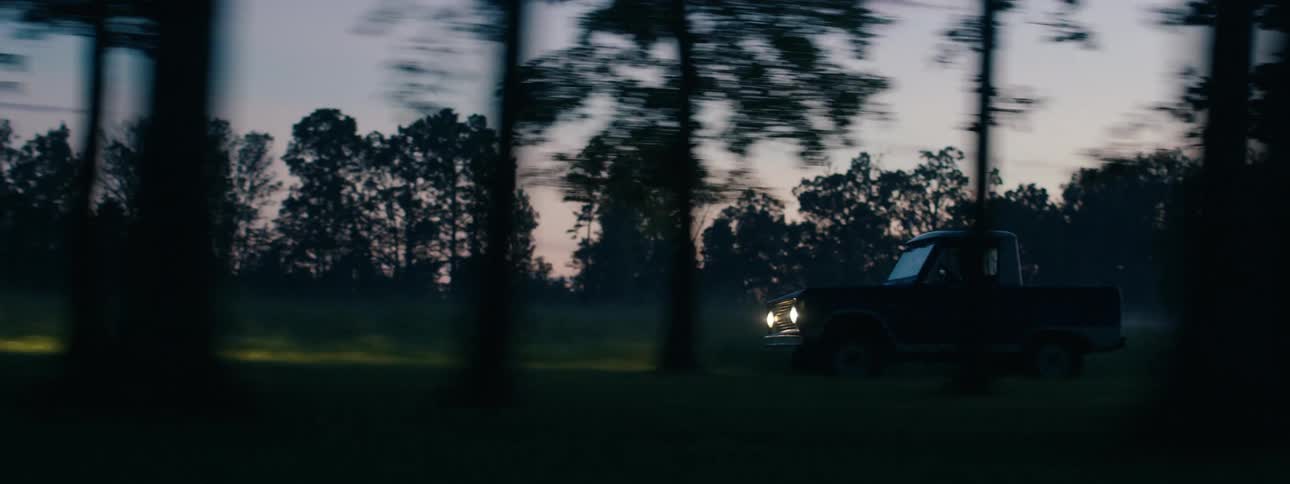 Vintage pickup truck driving on a rural road in the countryside at morning