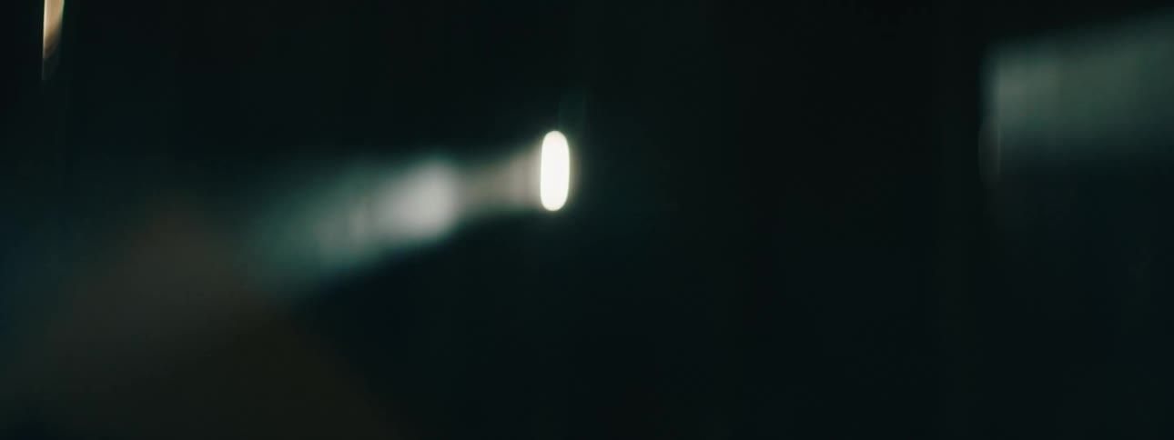 A beam of light shining through haze in darkness