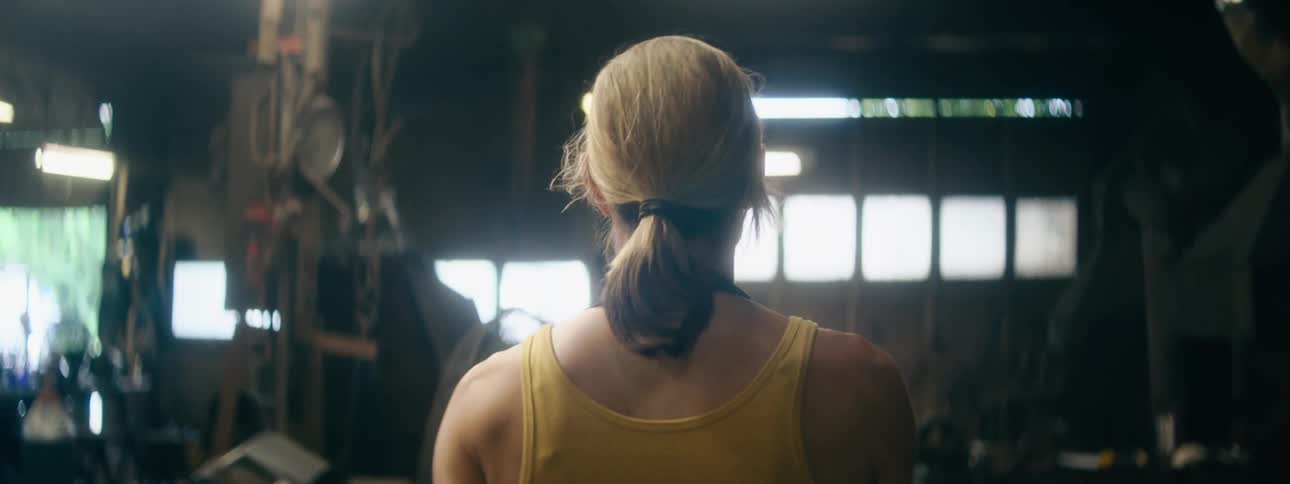 A woman walking in a workshop with a door in the background