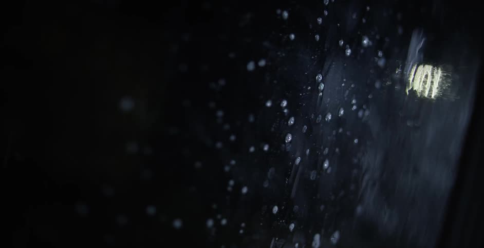 Rain is hitting glass at night