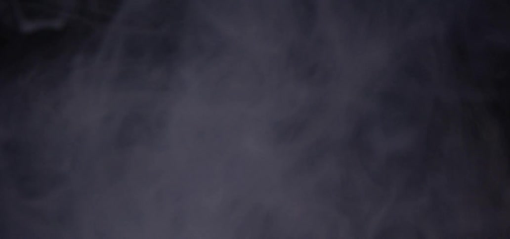 White smoke floating in a dark room