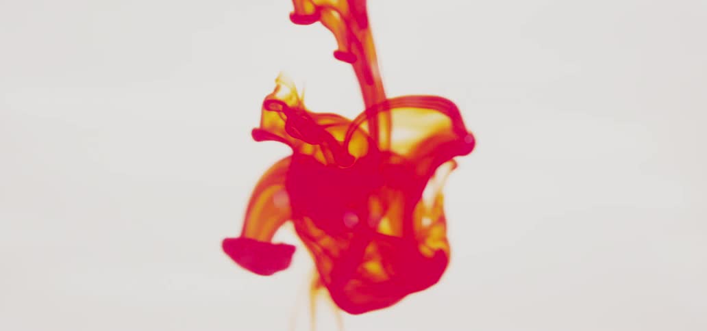 Red-orange liquid dropping and swirling around