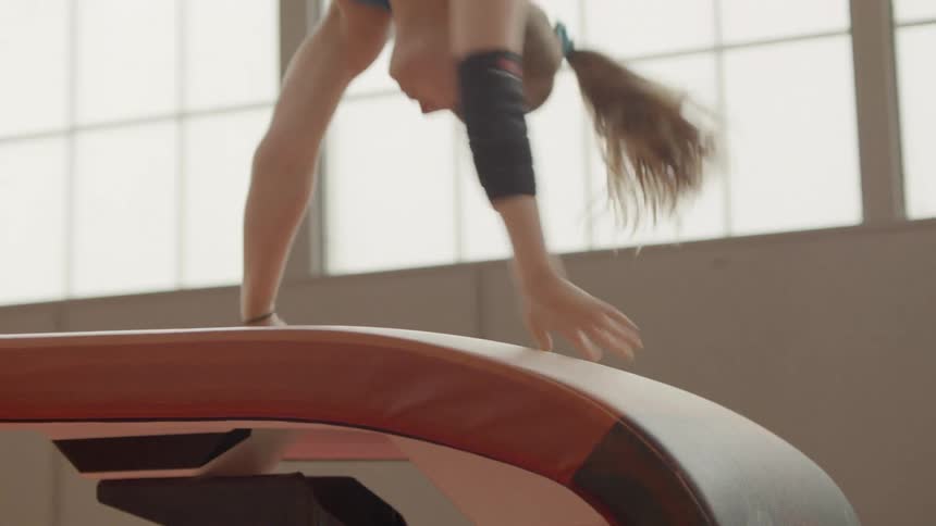 A gymnast does a flip on a vault