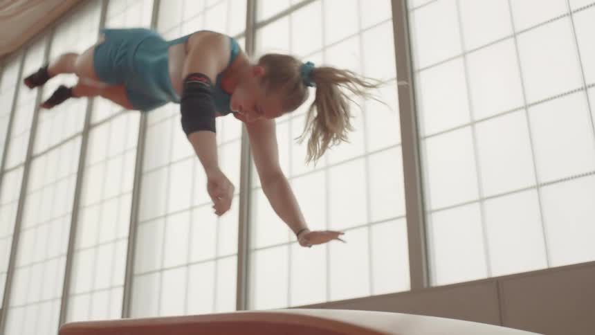 A gymnast does a flip on an apparatus
