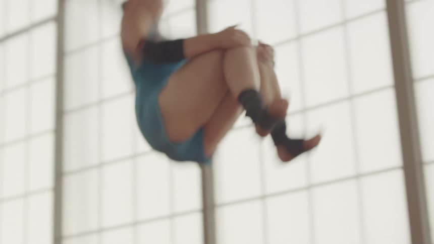 A gymnast does a flip on an apparatus