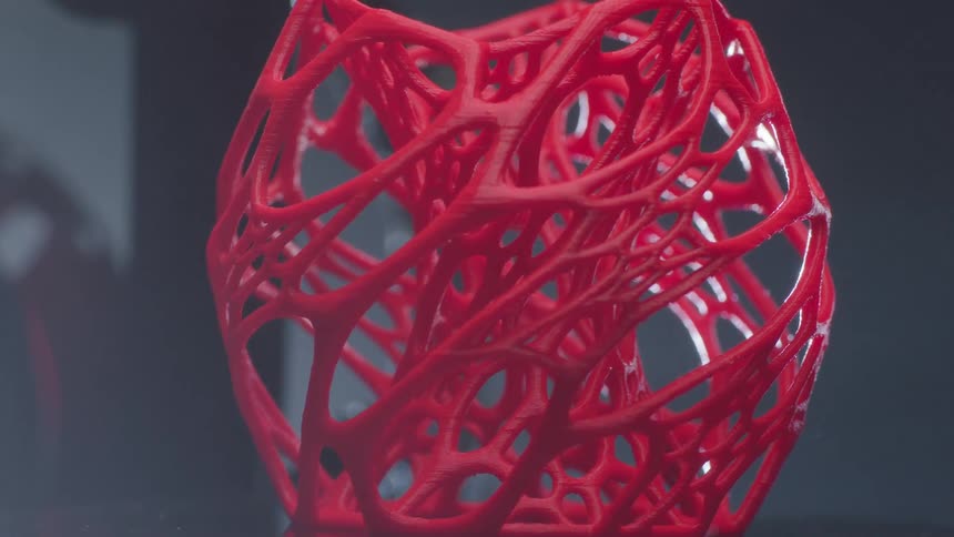 A light is shining on a red plastic sculpture