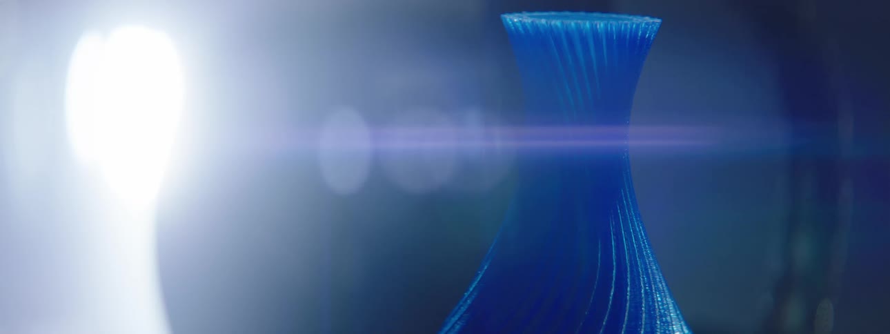 A very bright white light is shining on a blue vase