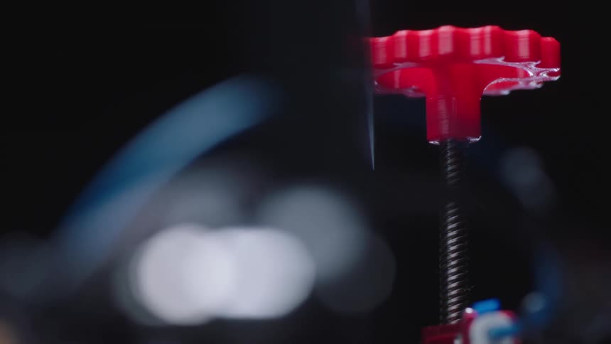 A large screw shaped piece on a machine spins clockwise as it self inserts