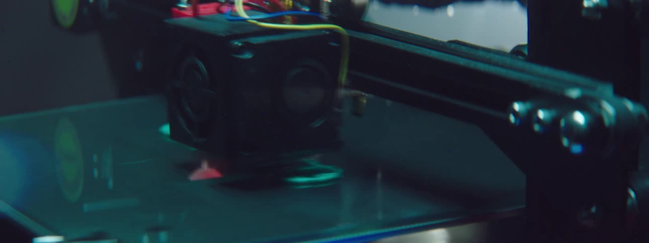 Print head moves over printer arm of 3d printer forming word by creating neon blue green letters
