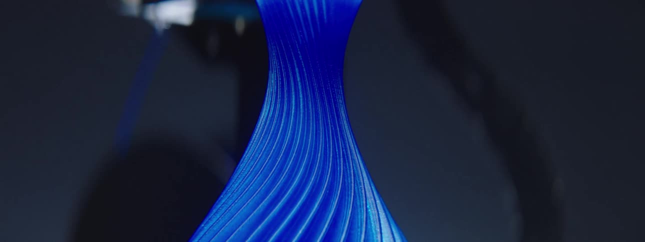 A blue vase with swirls printed on a 3d printer