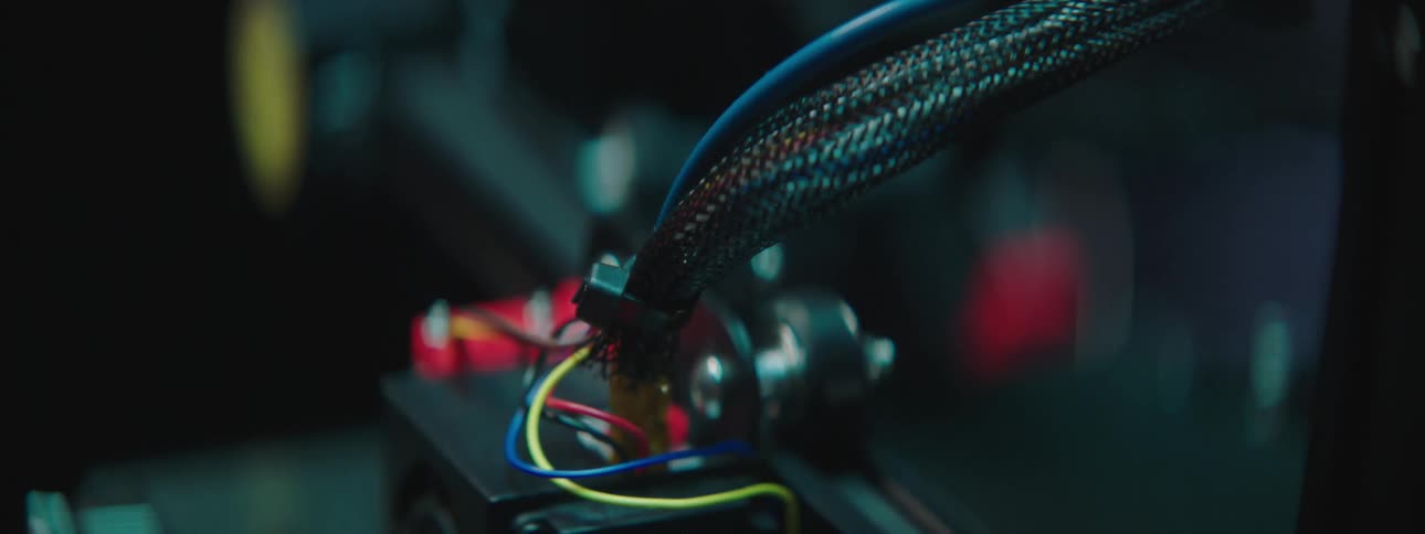 A machine moves a small stage back and forth as its head etches a piece of equipment