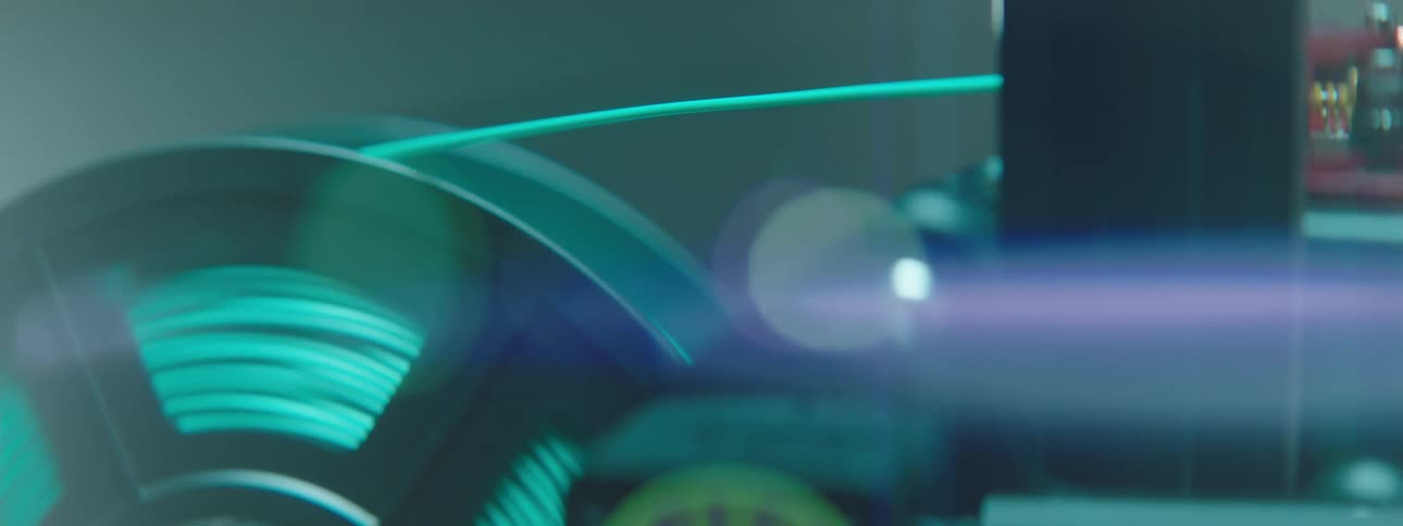 A spool of wire is threaded into an electronic device