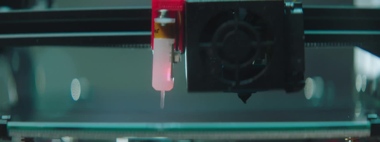 A 3d printer with a syringe system moves down a line