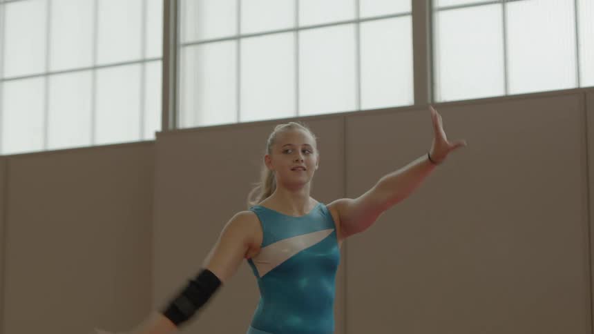 A gymnast stands and poses