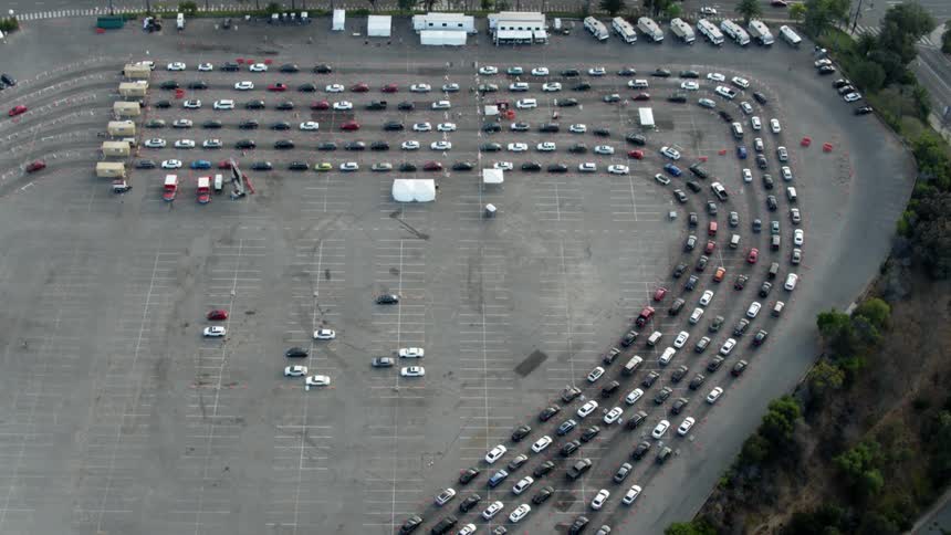 Traffic travels in lines through a large parking lot