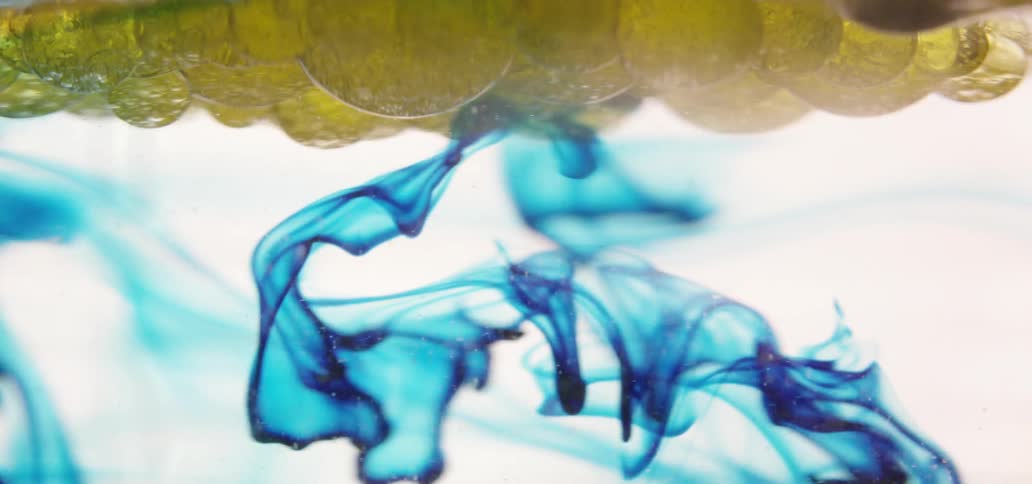 Blue liquid flows underneath a yellow bubbly substance