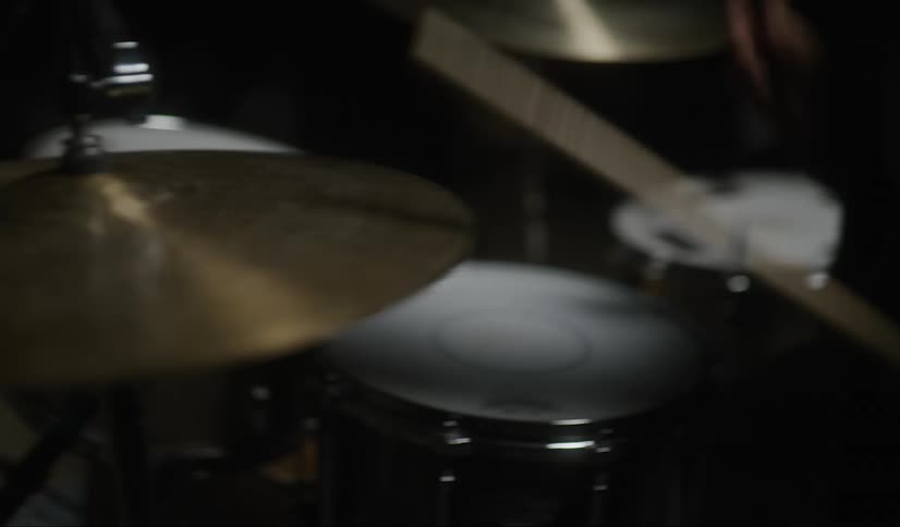 A man is playing the drums in a room