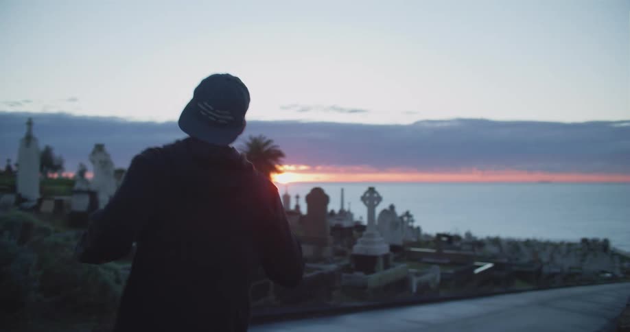 A man runs through an intersection in a cemetery on the coast