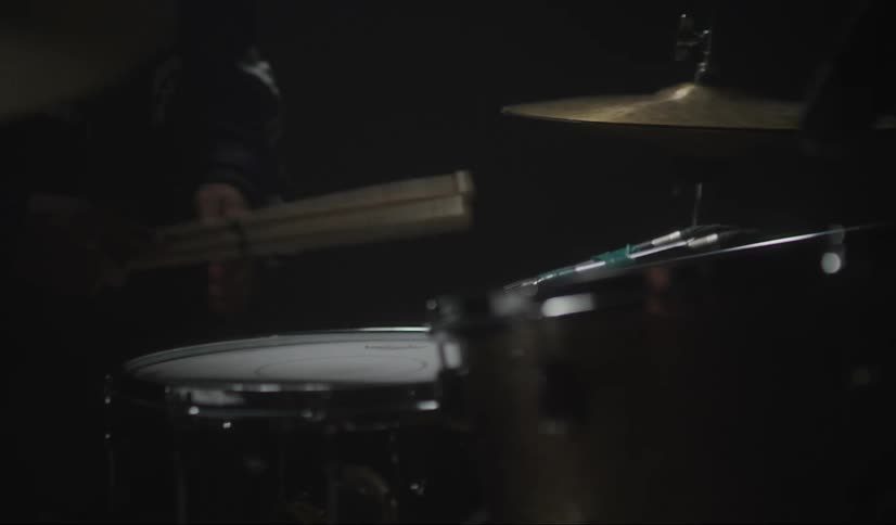 A man sets his drum sticks down after playing