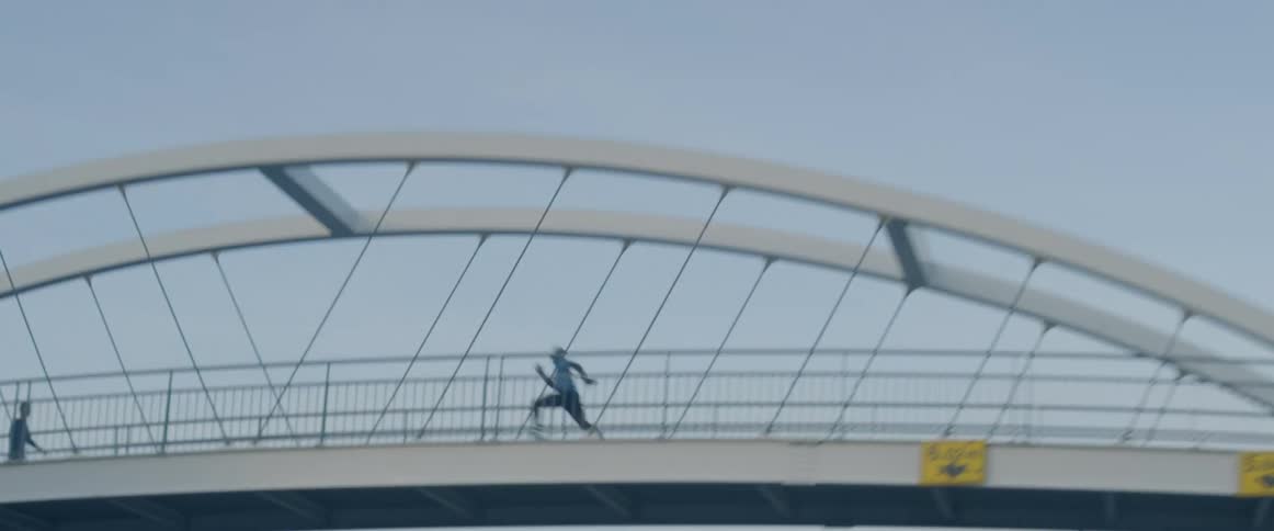 A man sprints across a bridge