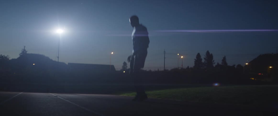 A man is stretching outside at night