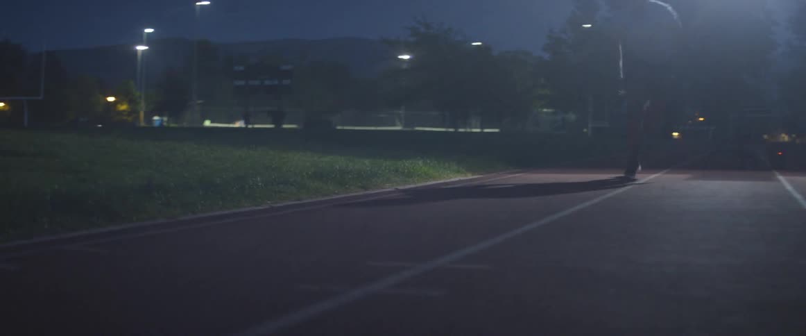 A man races on the track at night