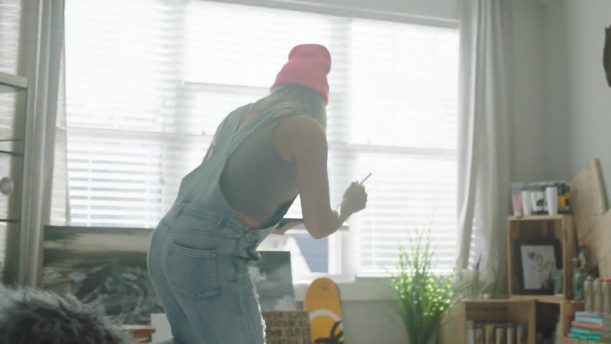 A woman walks over to the couch with a tablet